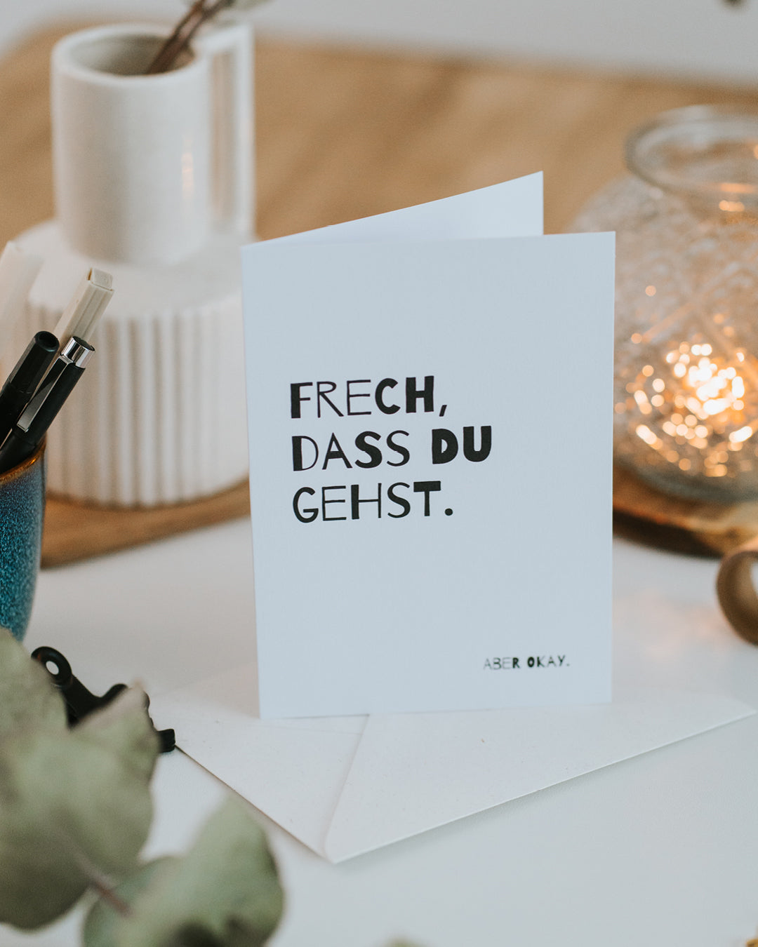 Aufgestellte Klappkarte „Frech, dass du gehst. Aber okay.“ mit Umschlag, kräftige Typografie.