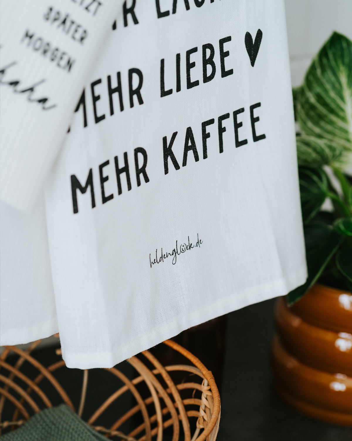 Nahaufnahme Geschirrtuch – „Mehr Liebe. Mehr Kaffee.“