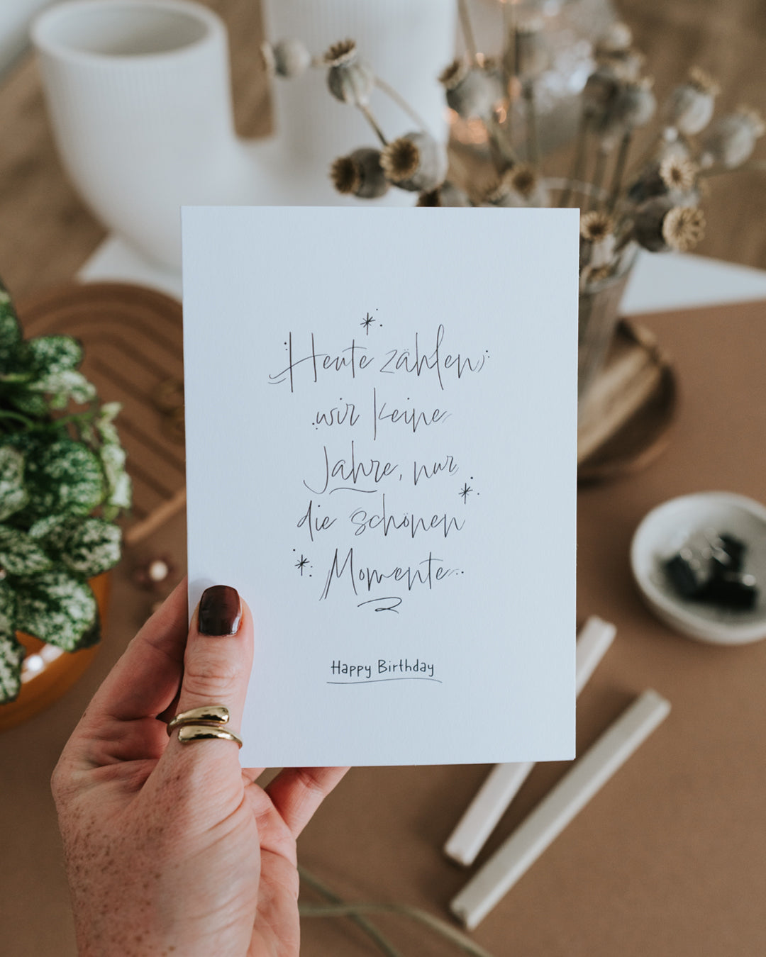 Hand hält Klappkarte zum Geburtstag mit feinem Handlettering und Happy-Birthday-Schriftzug.