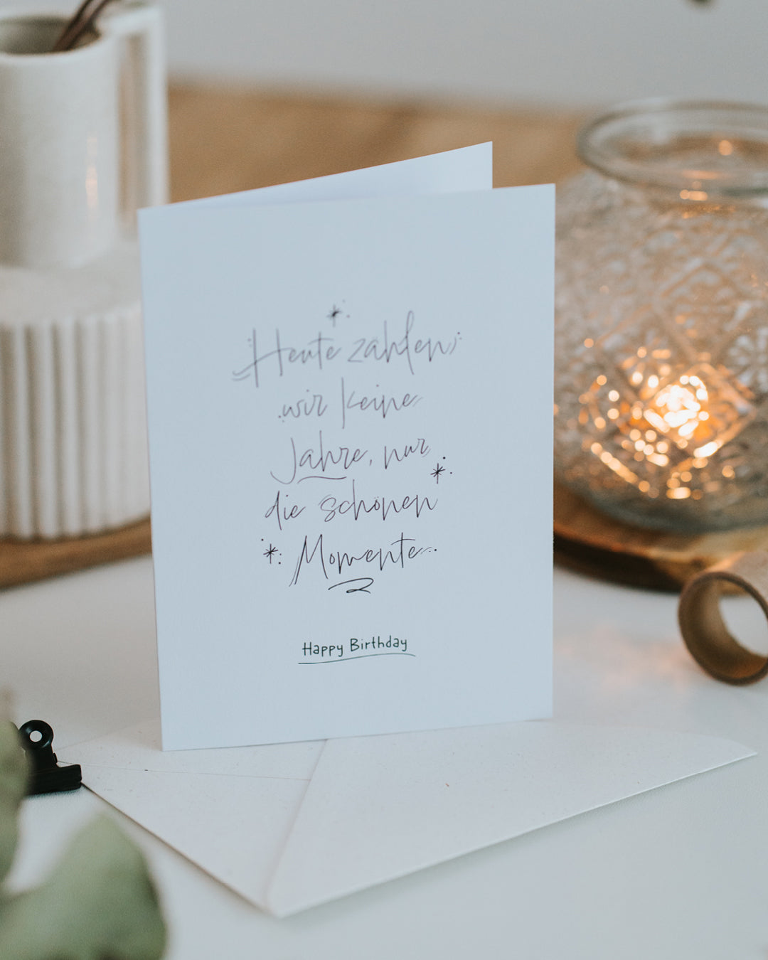 Geburtstagskarte „Happy Birthday“ aufgestellt vor Umschlag, elegantes Schwarz-Weiß-Lettering.
