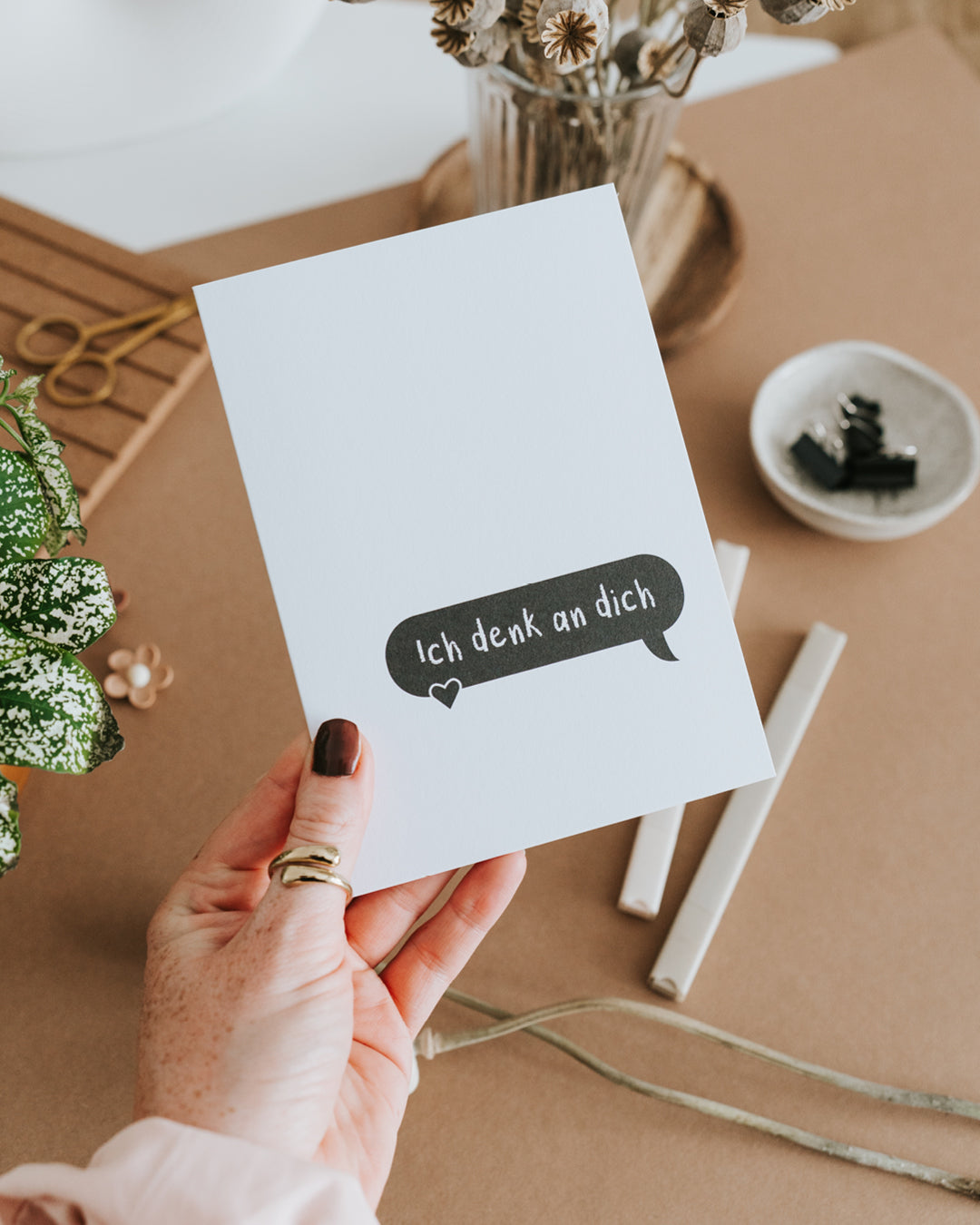 Hand hält Klappkarte „Ich denk an dich“ – hochwertiges Papier, reduziertes Schwarz-Weiß-Design.