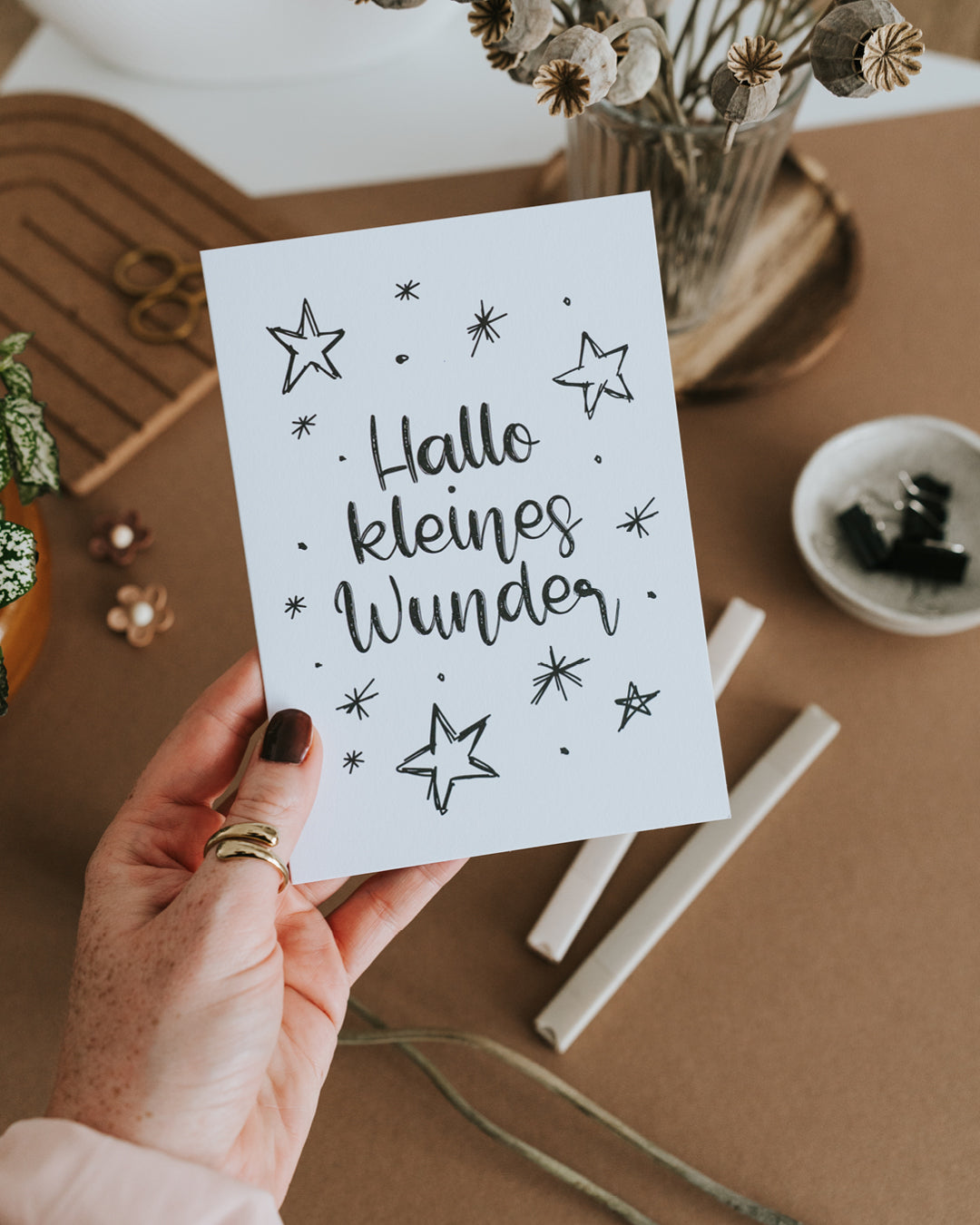 Hand hält Geburtskarte „Hallo kleines Wunder“ auf hochwertigem Papier im Hochformat.