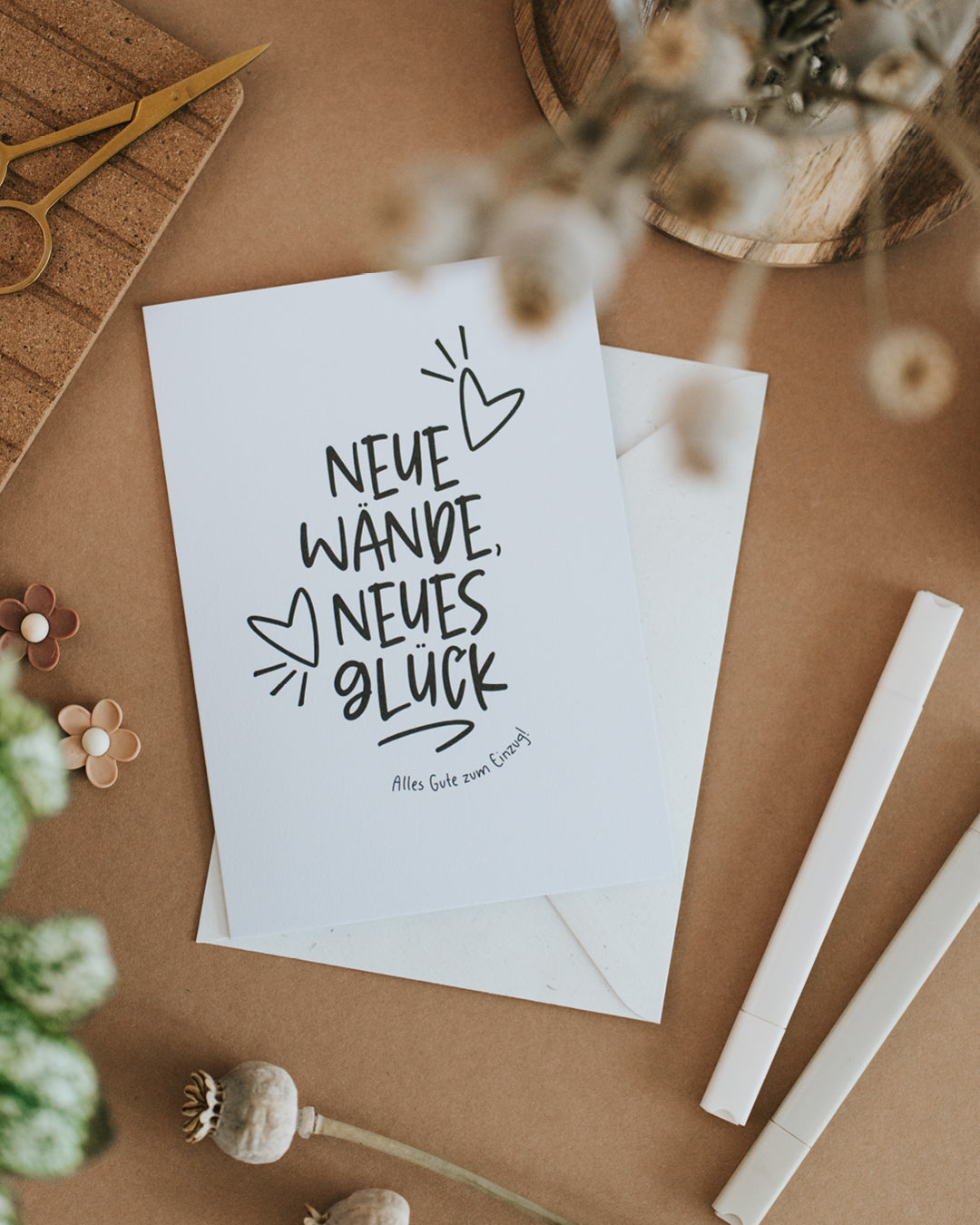 Klappkarte zum Einzug „Neue Wände, neues Glück“ auf Umschlag liegend, Schwarz-Weiß-Design.