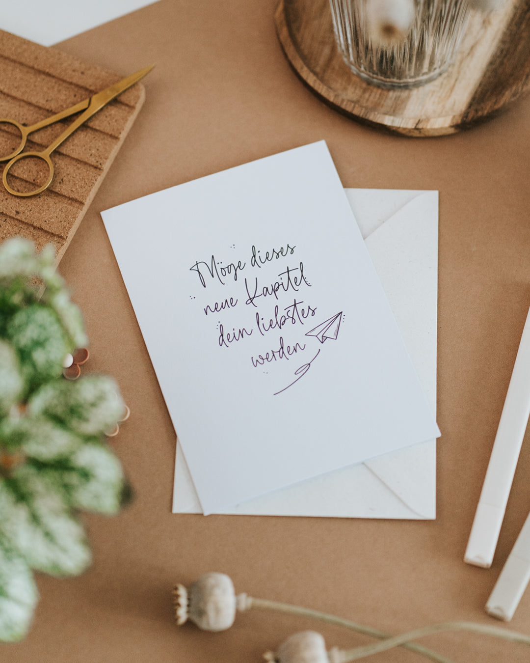 Karte zum Neuanfang mit Papierflieger-Motiv, liegend auf passendem Umschlag.