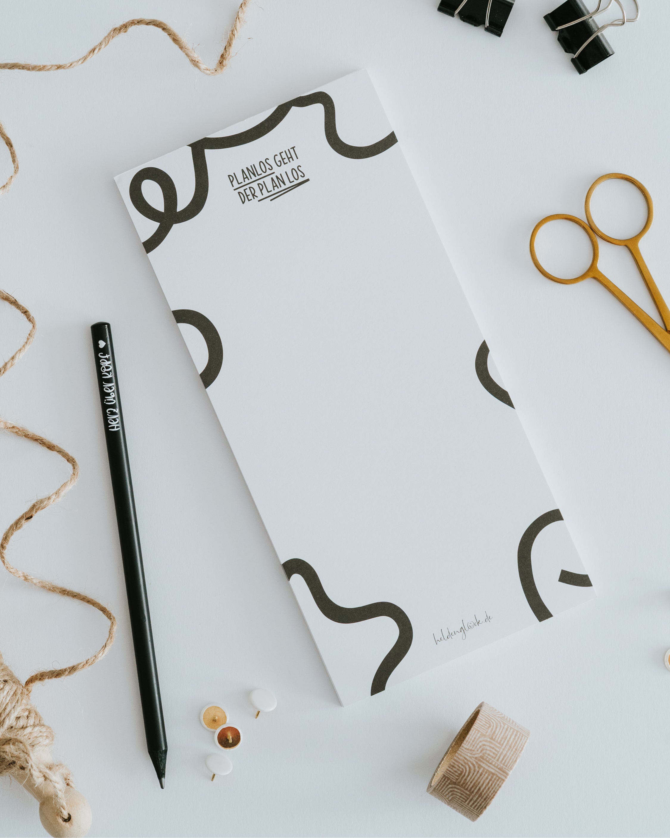 Unser Heldenglück Notizblock mit der schwarzen Aufschrift motiviert auf humorvolle Weise dazu, einfach mal anzufangen und wild zu improvisieren.