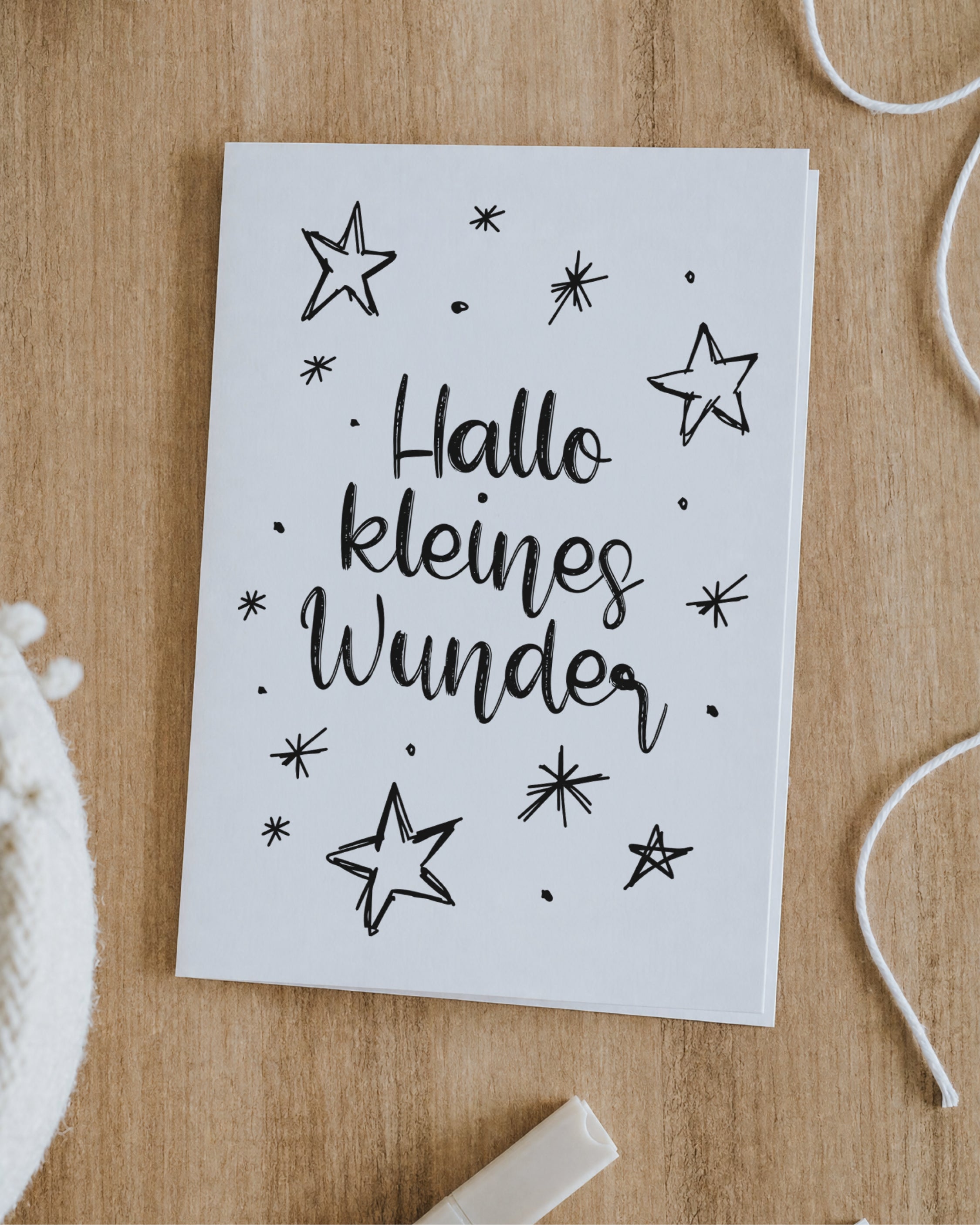 Klappkarte zur Geburt „Hallo kleines Wunder. Willkommen auf der Welt!“ in Weiß auf schwarzem Sternenhimmel