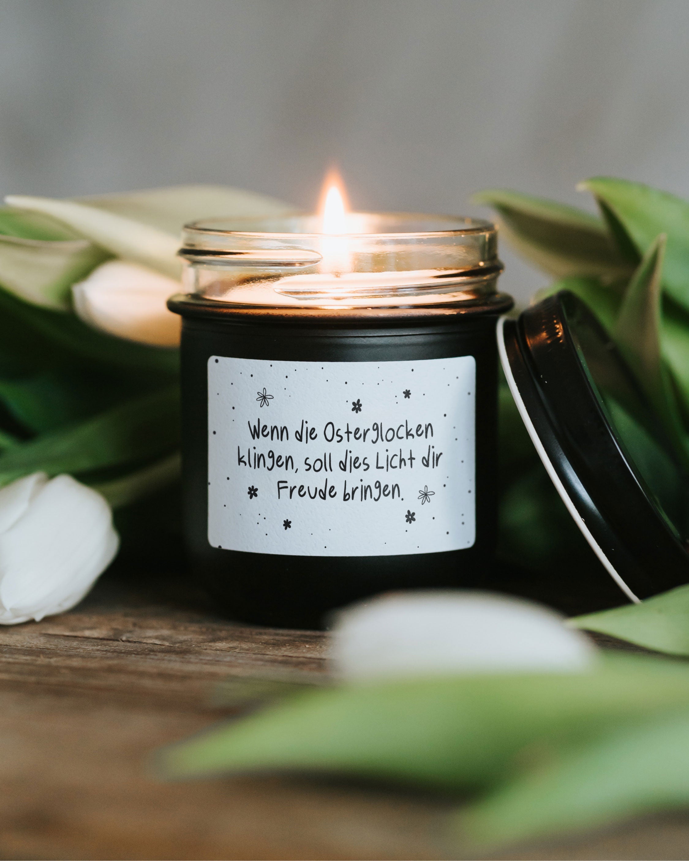 Minimalistische Osterkerze im Glas mit typografischem Spruch und ruhigem Design