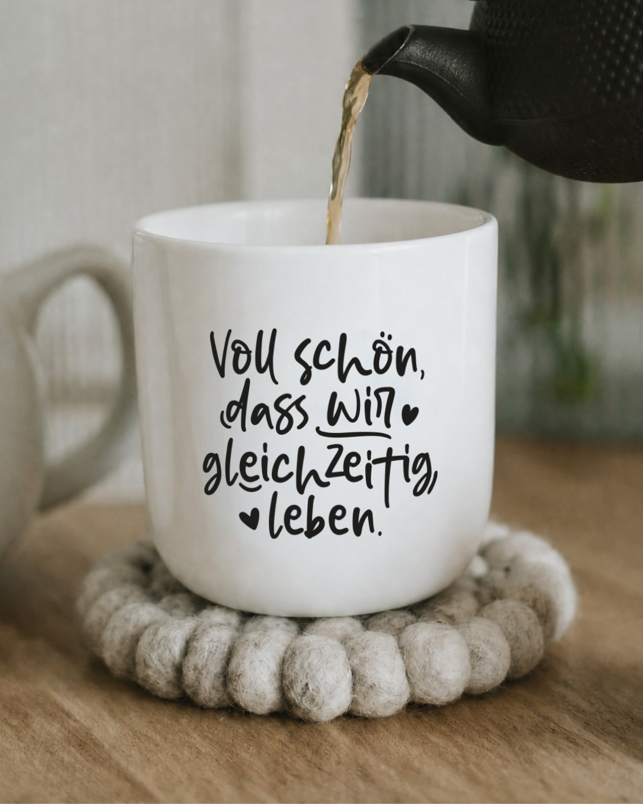 Weißer Porzellanbecher mit schlichtem Schriftzug