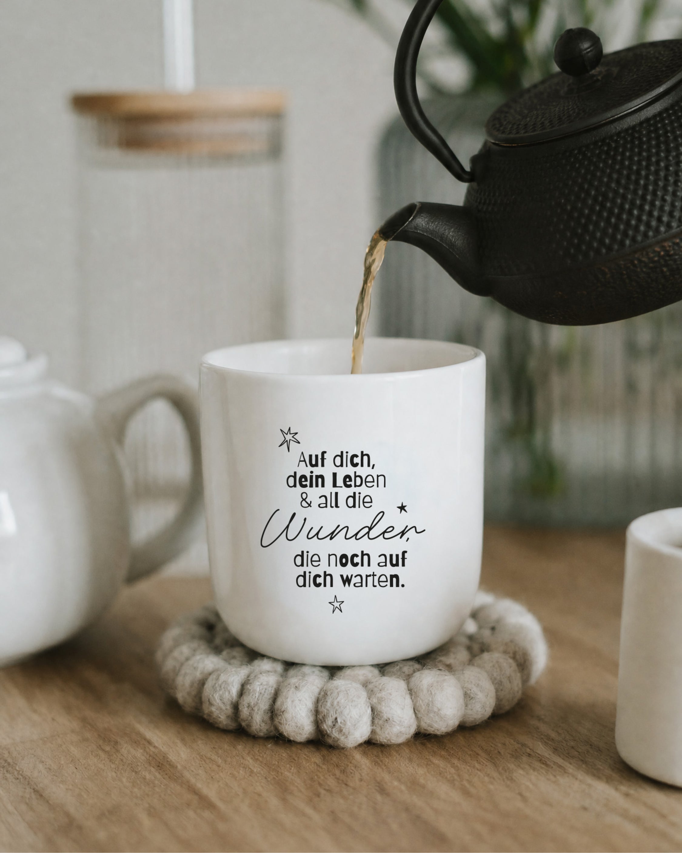 Henkelloser Porzellanbecher in Weiß mit schwarzer Typografie